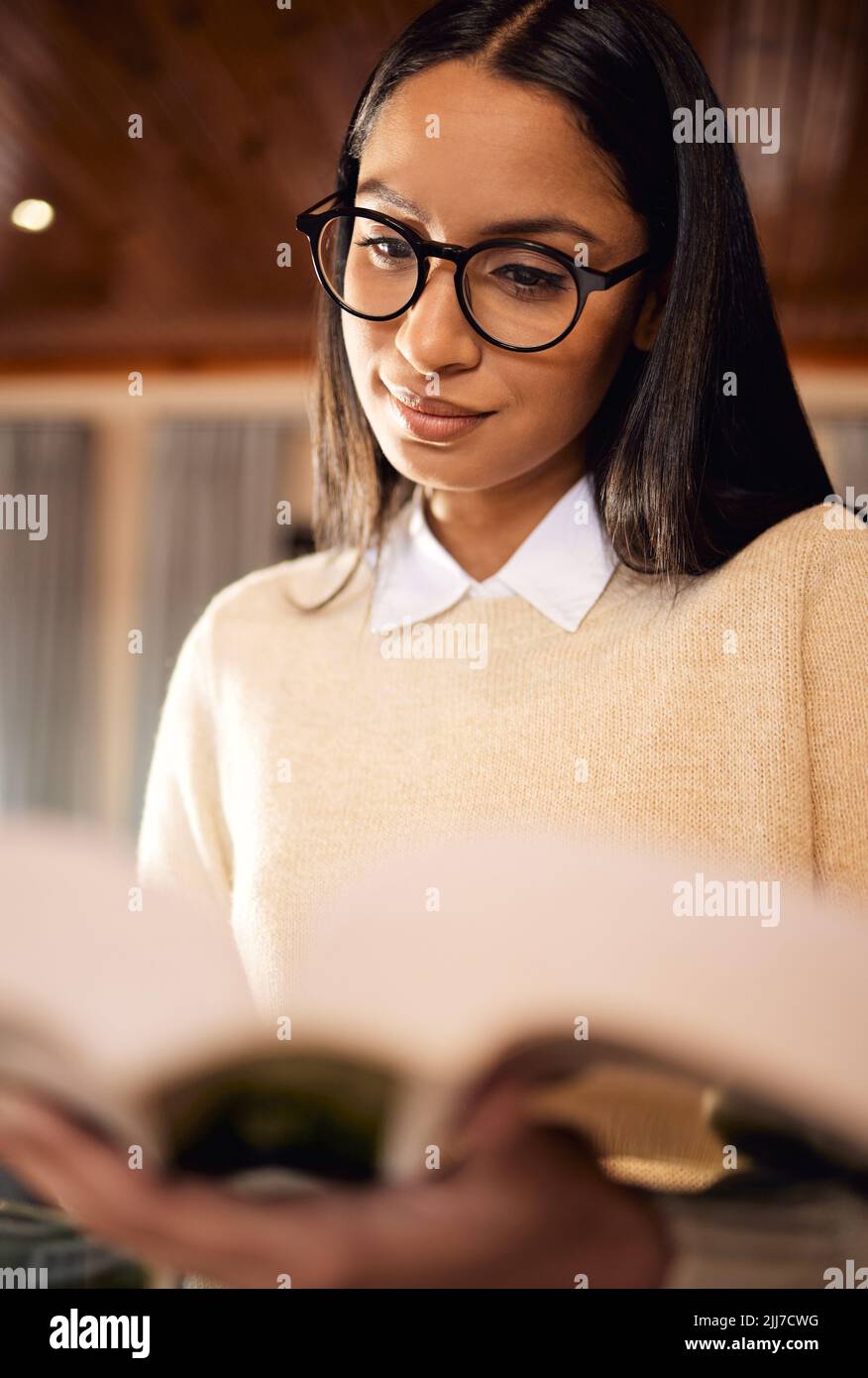 Alles, was Sie lernen, wird Ihnen in Ihrer Zukunft helfen. Eine Studentin trägt eine Brille beim Lesen zu Hause. Stockfoto