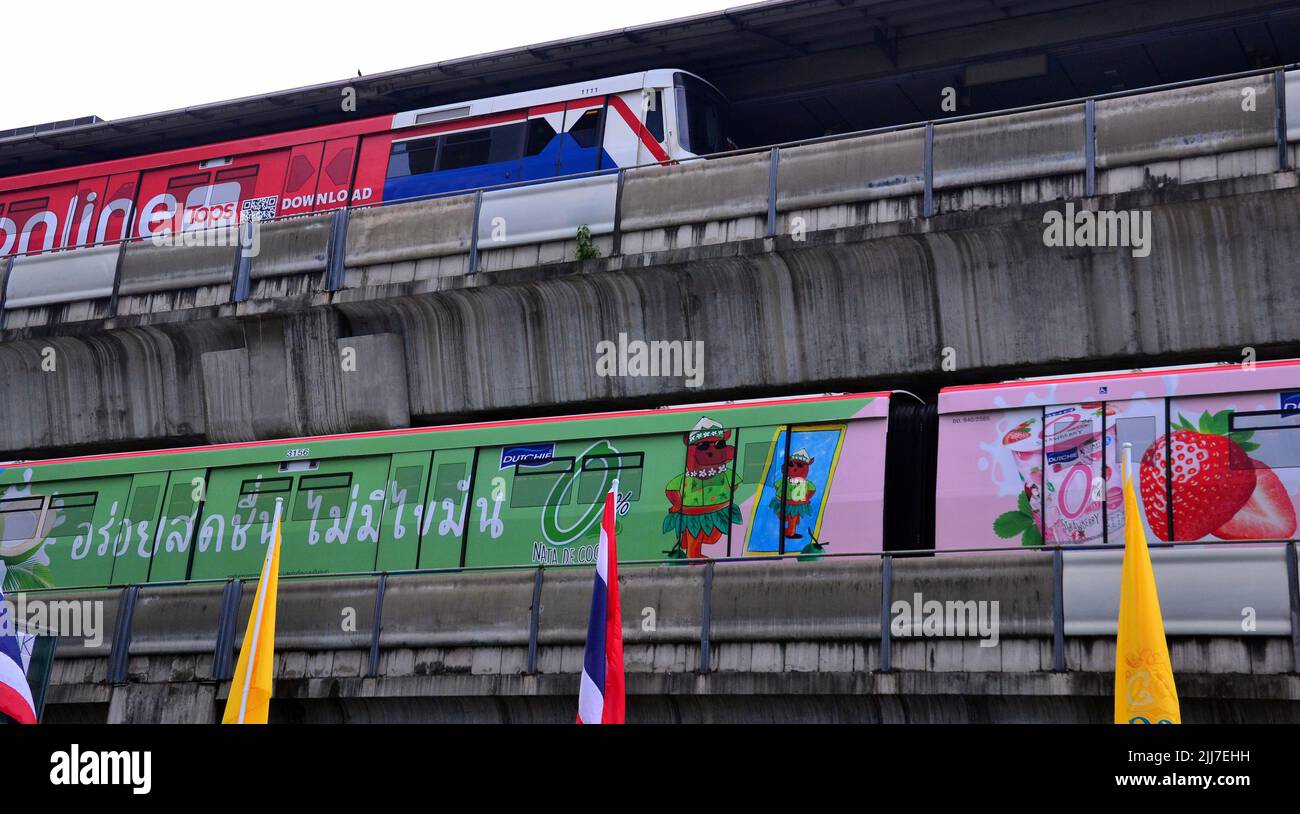 BTS Skytrains, Teil eines erhöhten S-Bahn-Systems in Bangkok, Thailand, und Umgebung, fahren in entgegengesetzte Richtungen auf übereinander liegenden Linien am BTS-Bahnhof Siam in Bangkok, Thailand, Asien. Stockfoto