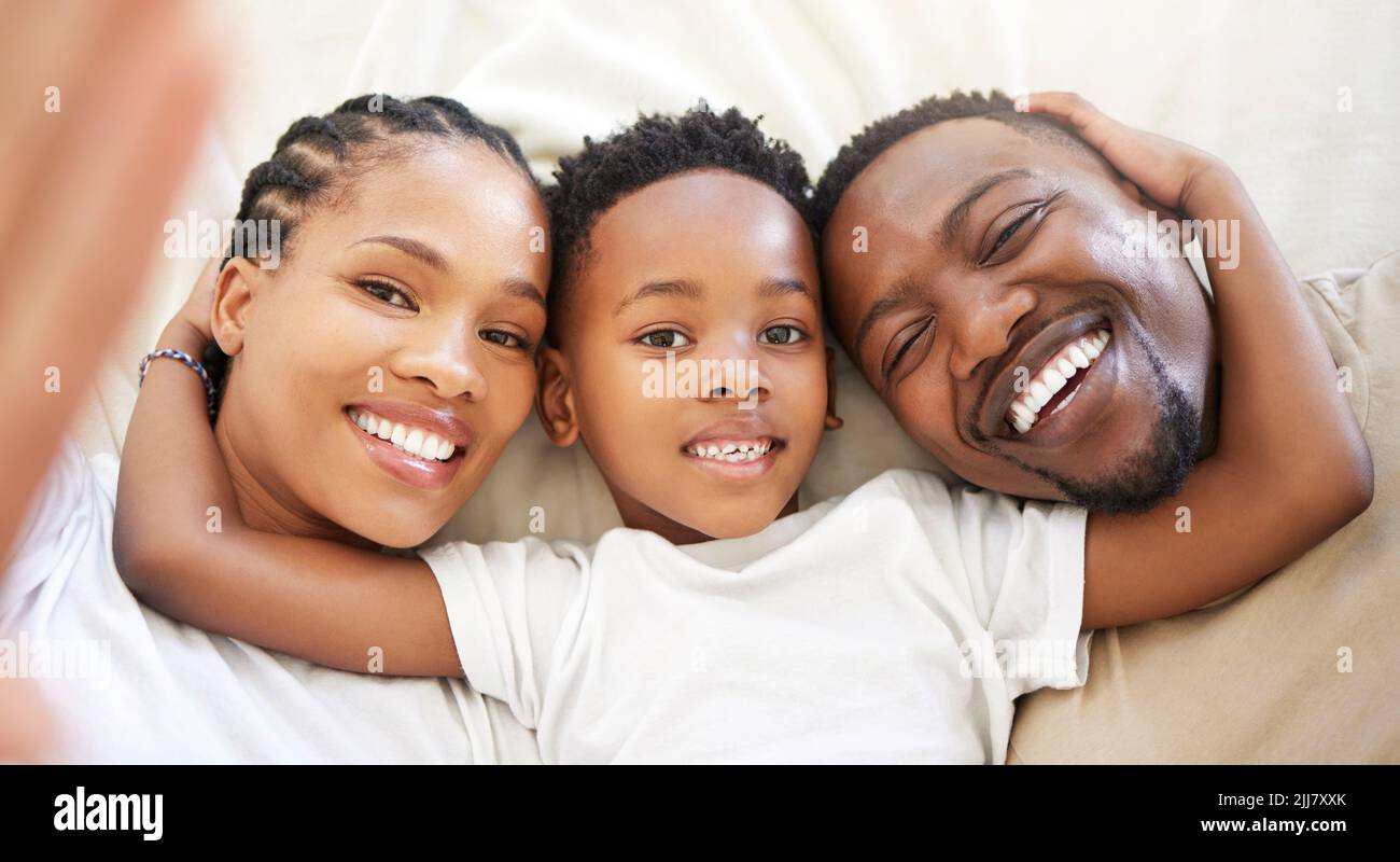 Jeder Mann muss Zeit mit seiner Familie verbringen. Eine schöne junge Familie, die sich im Bett verbindet. Stockfoto