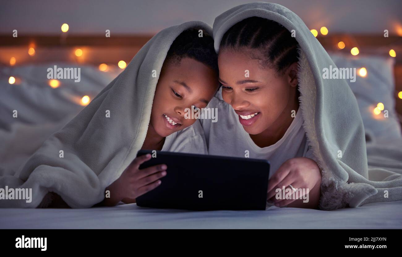 Sie werden lieben und geliebt werden. Eine Mutter und ein Sohn mit einem Tablet im Bett a t zu Hause. Stockfoto