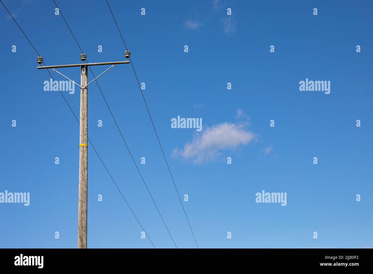 Alte hölzerne Strommast oder elektrische Stange gegen blauen Himmel in Orivesi, Finnland Stockfoto