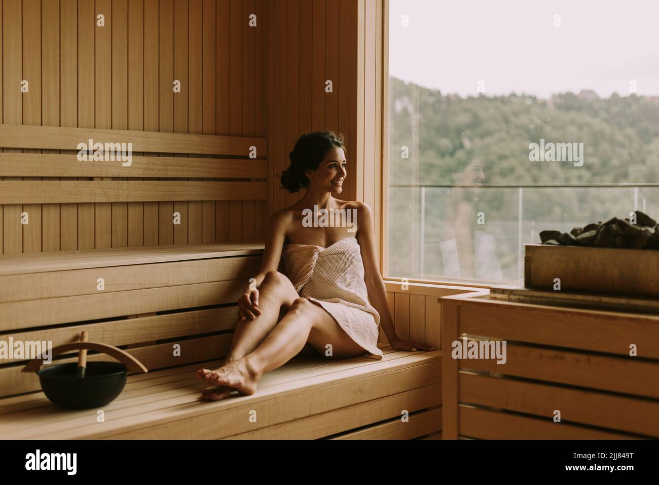 Attraktive junge Frau, die sich in der Sauna entspannt Stockfoto