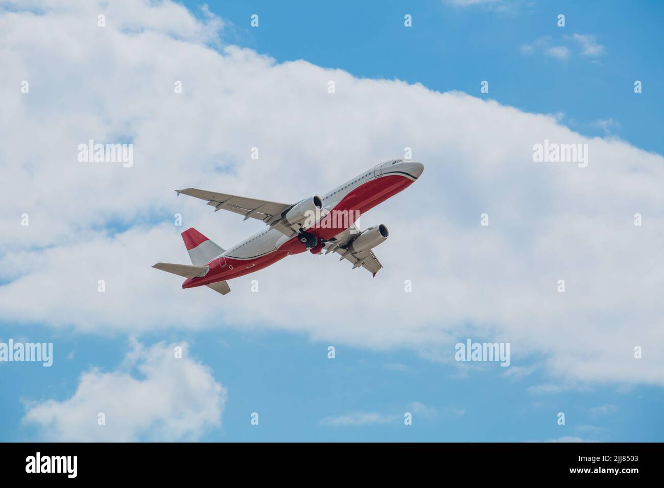 Passagierflugzeug der weiß-roten Farbe fliegt in den blauen Himmel mit weißen Wolken, Luftverkehrskonzept, Bevölkerung Evakuierung. Stockfoto