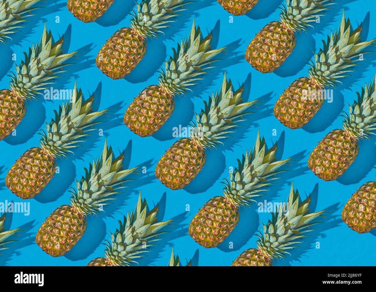 Ananasfrüchte auf hellblauem Hintergrund. Mesh-Muster mit Schatten. Tropischer Sommer Food Hintergrund. Stockfoto