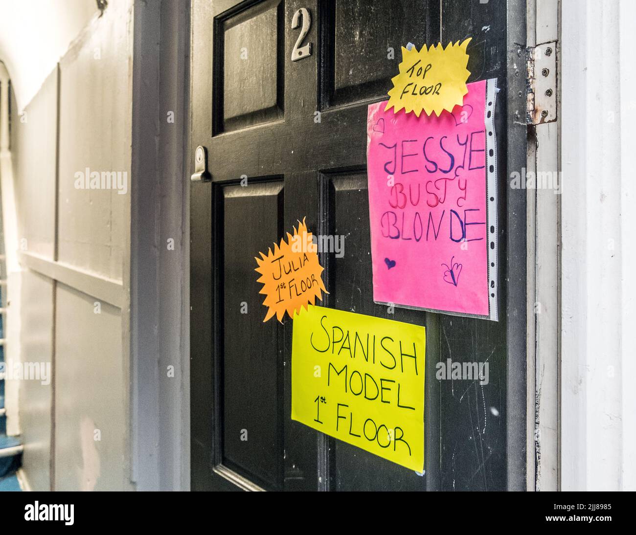 Prostituierte beworben am Eingang zum Bordell in China Town, Soho, London, England, Großbritannien. Stockfoto