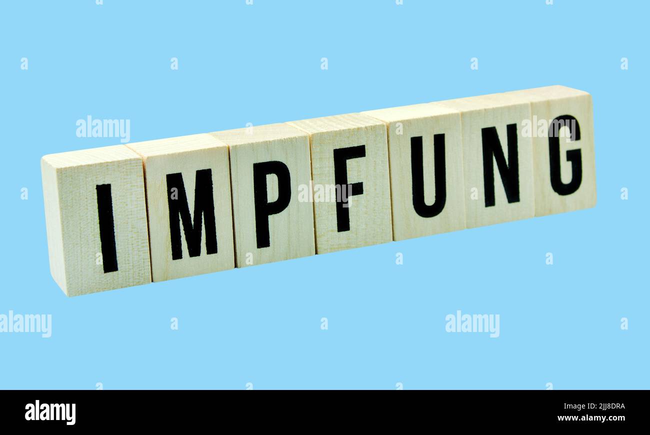 Deutsche Impfung auf Holzwürfeln und blauem Hintergrund Stockfoto