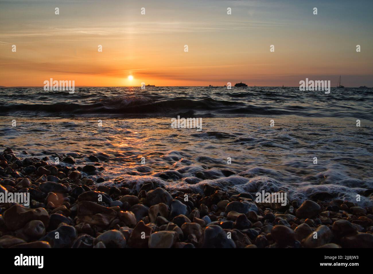 Eine schöne und ästhetische Ansicht der Meereswellen unter dem Sonnenuntergang Licht in der Isle of Wight, England - ideal für Hintergründe Stockfoto