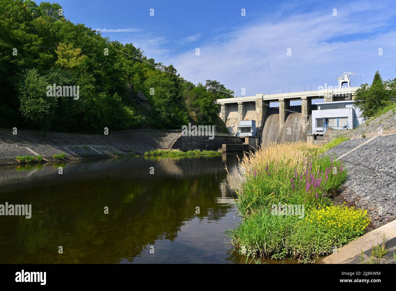 Ein Damm auf dem Brünner Stausee am Fluss Svratka mit einem kleinen Kraftwerk. Schöner sonniger Sommertag in der Natur. Stockfoto