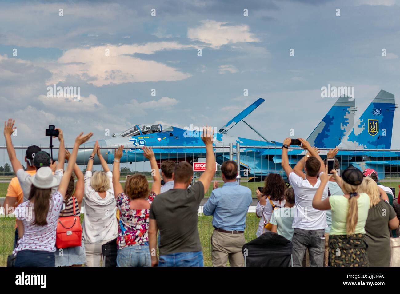 SIAULIAI / LITAUEN - 27. Juli 2019: Zuschauer begrüßen und winken den ukrainischen Luftstreitkräften Sukhoi Su-27, die auf dem Rollfeld des Kampfflugzeugs rollten Stockfoto