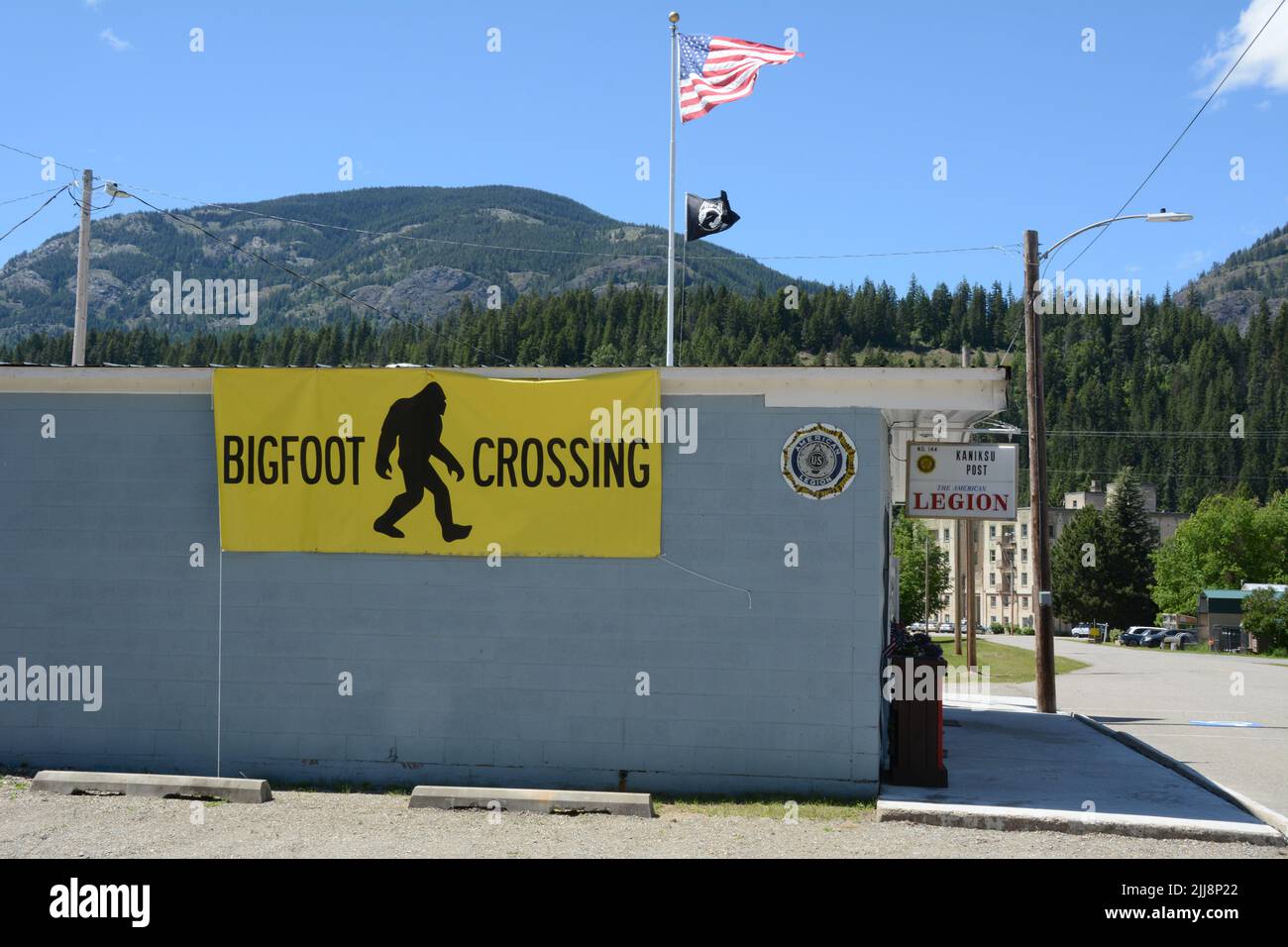 Ein Bigfoot Crossing Banner an der Seite einer American Legion Hall in der Stadt MetaLine Falls, Pend-Oreille County, Washington State, USA. Stockfoto