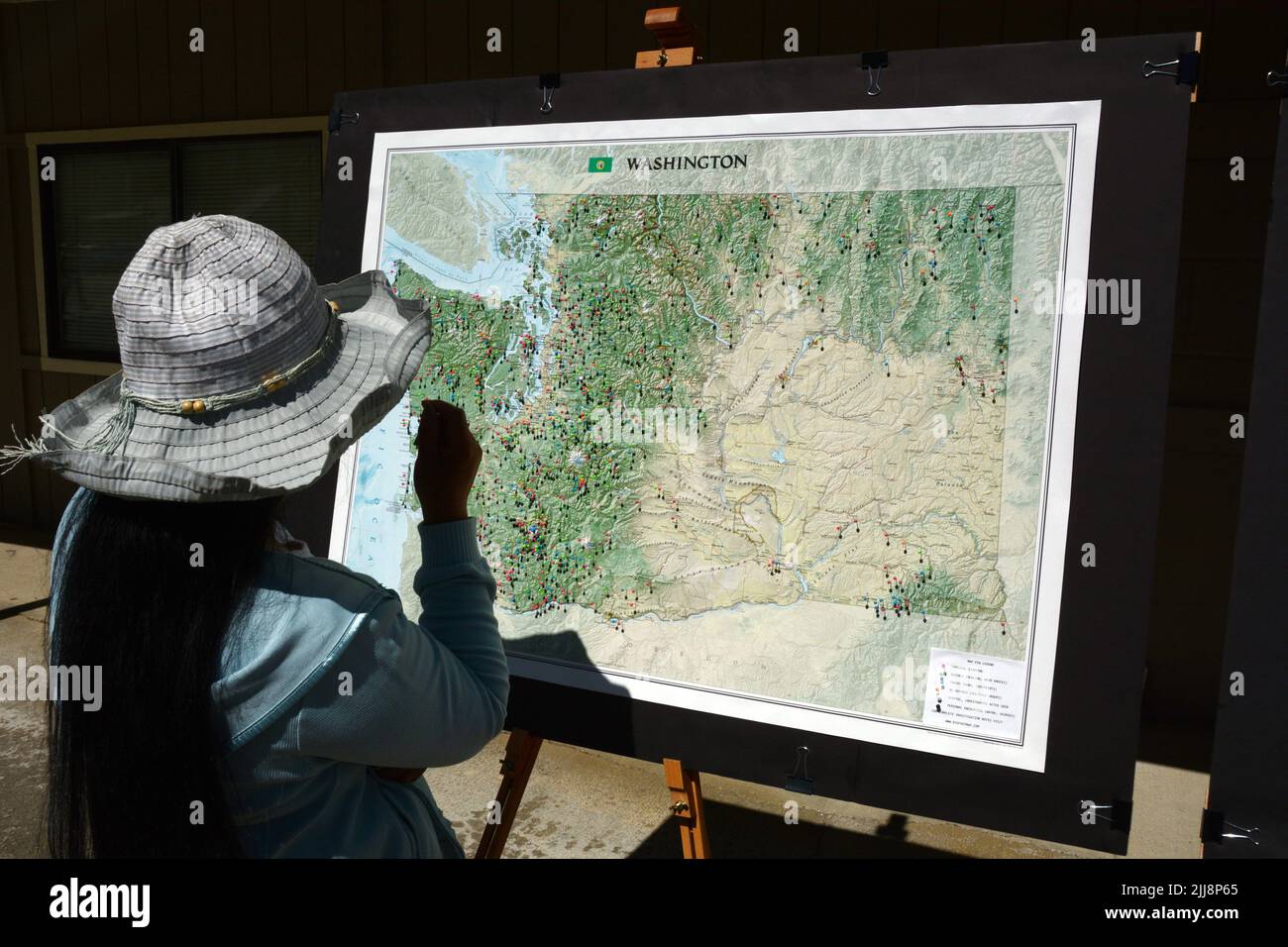 Frau, die sich eine Karte mit den Standorten der Sasquatch-Sichtungen ansieht, die beim MetaLine Falls Bigfoot Festival im Bundesstaat Washington, USA, ausgestellt werden. Stockfoto