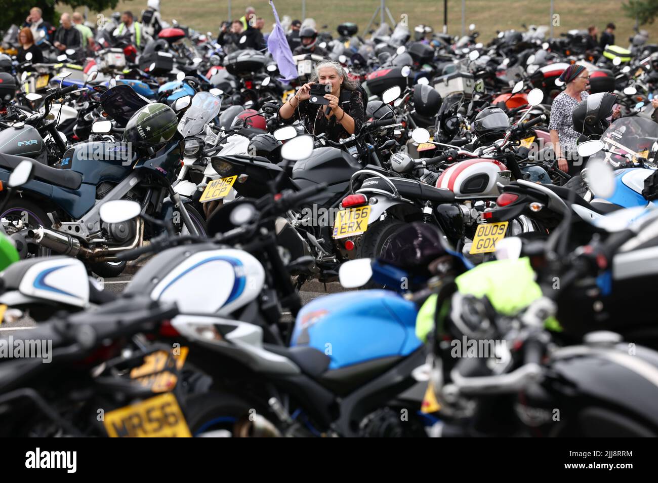 Hinckley, Leicestershire, Großbritannien. 24.. Juli 2022. Eine Frau fotografiert das Motorrad während eines Weltrekordversuchs für das größte Motorradtreffen der Frauen am globalen Hauptsitz von Triumph Motorcycles. Credit Darren Staples/Alamy Live News. Stockfoto