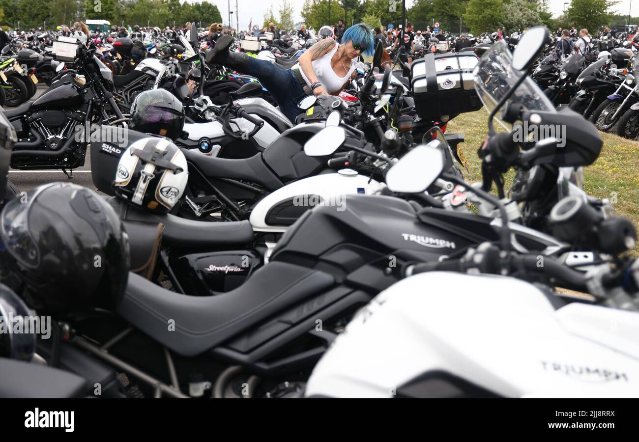 Hinckley, Leicestershire, Großbritannien. 24.. Juli 2022. Eine Fahrerin montiert ihr Motorrad während eines Weltrekordversuchs für das größte Biker-Treffen in der weltweiten Zentrale von Triumph Motorcycles. Credit Darren Staples/Alamy Live News. Stockfoto