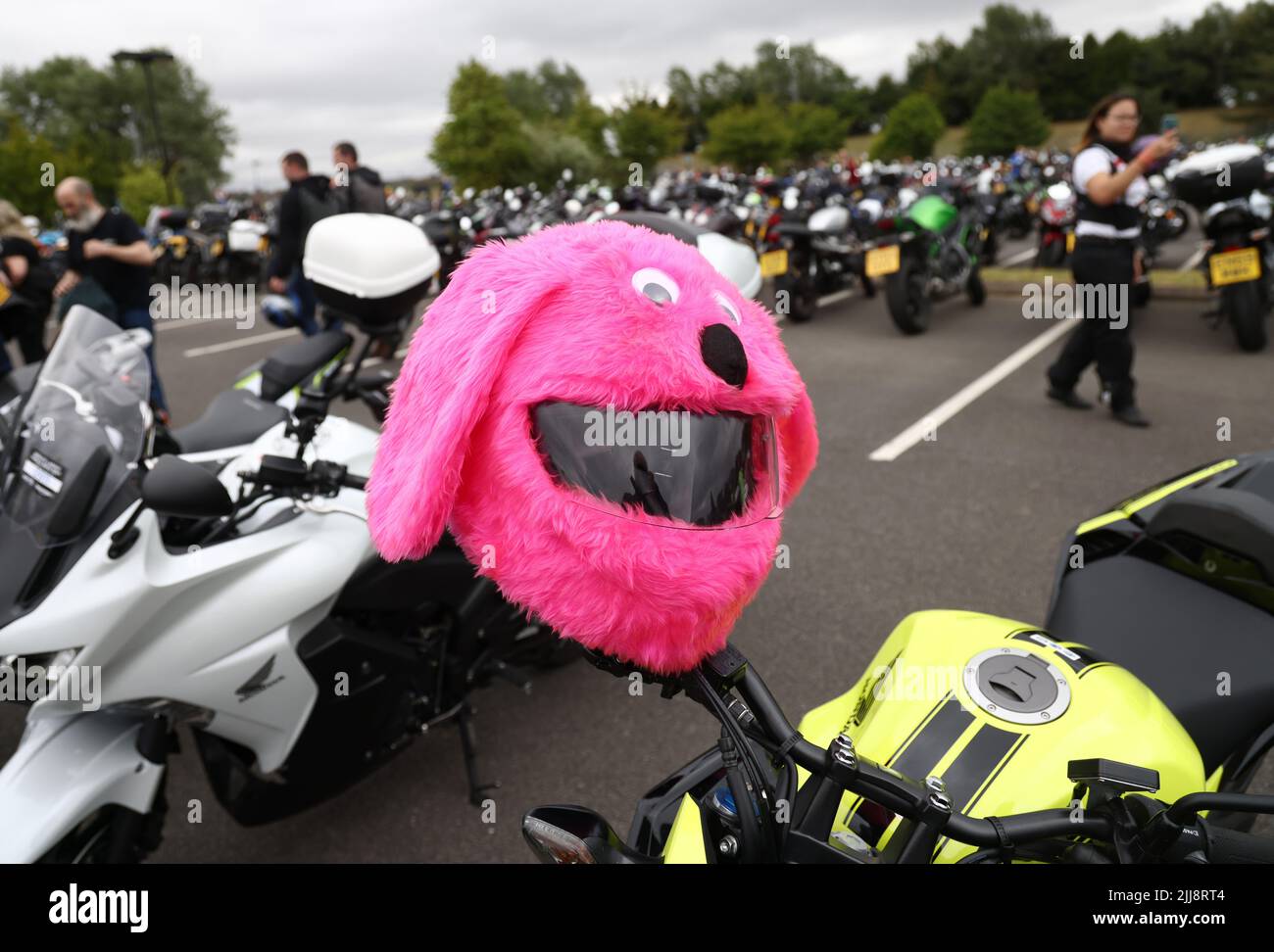 Hinckley, Leicestershire, Großbritannien. 24.. Juli 2022. Ein rosafarbener flauschiger Fahrradhelm hängt an einem Motorrad während eines Weltrekordversuchs für das größte Biker-Treffen der Frauen am globalen Hauptsitz von Triumph Motorcycles. Credit Darren Staples/Alamy Live News. Stockfoto