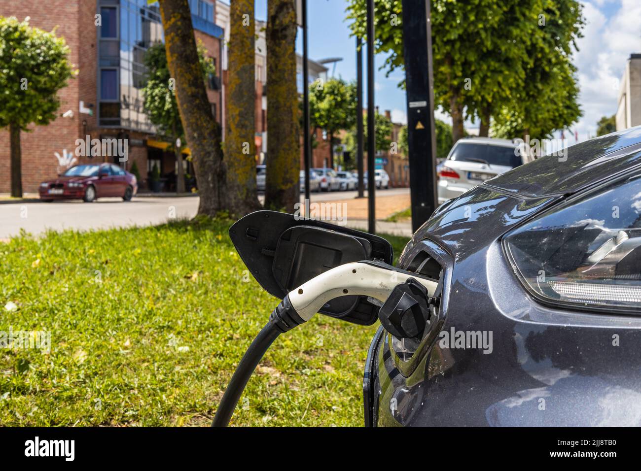 Elektrofahrzeug oder Elektroauto mit eingestecktem Netzkabel Stockfoto