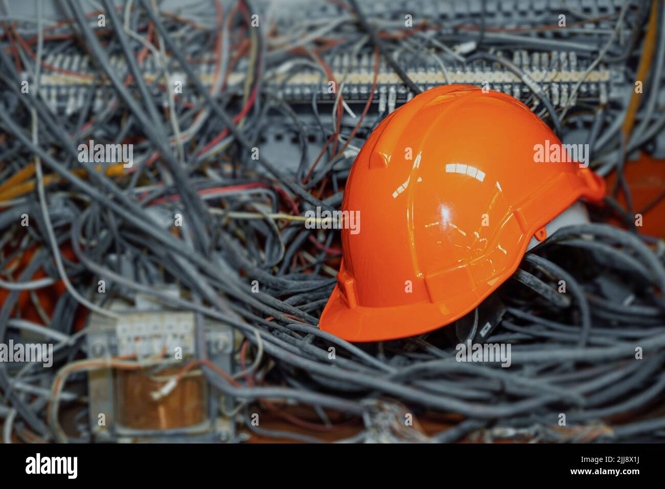 Unordentliche Kabel Strom- und Kommunikationsleitungen mit Techniker Arbeiter Hardhat Sicherheitshelm. Stockfoto