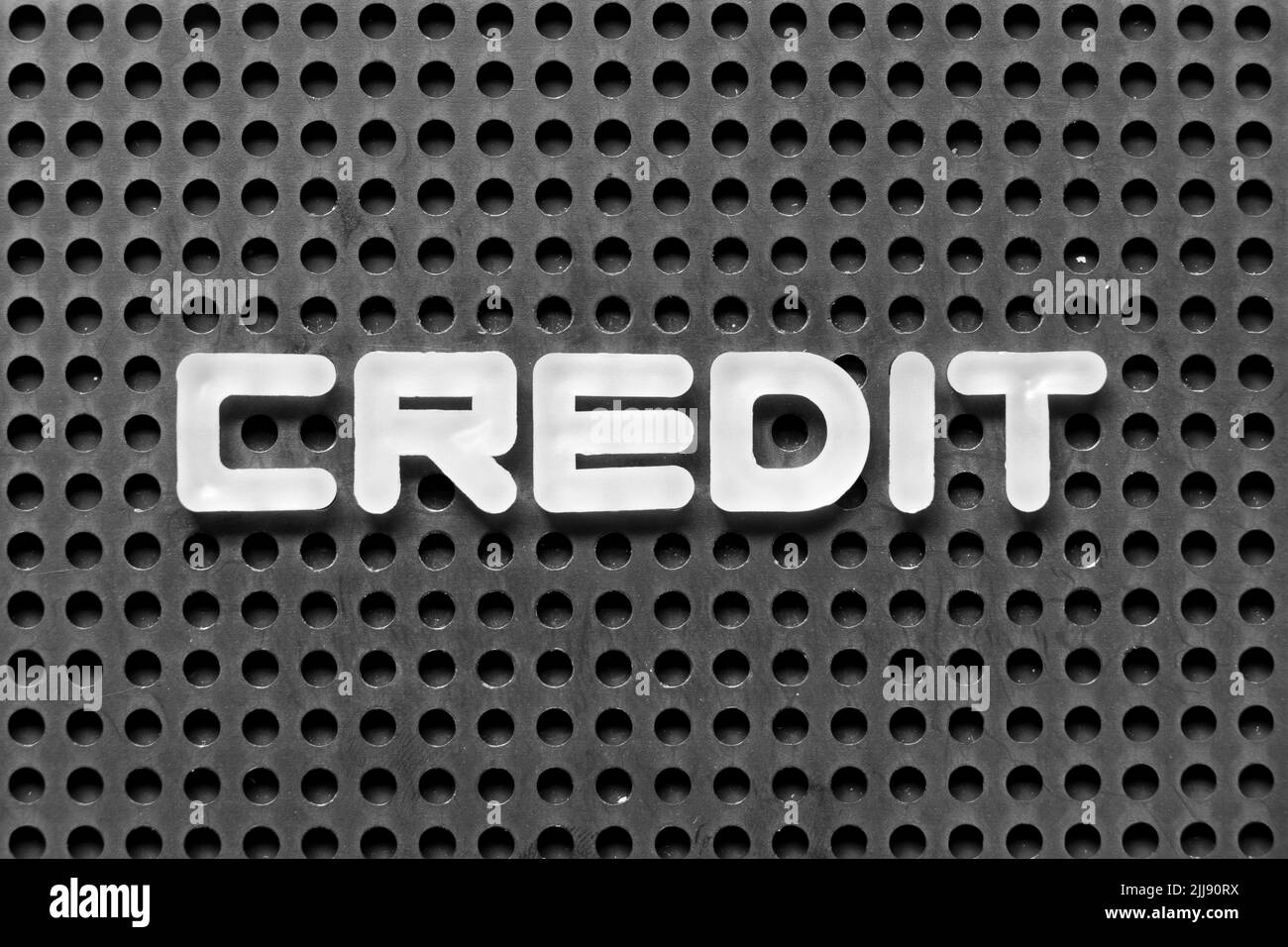 Weißer Buchstabe im Wort Gutschrift auf schwarzem pegboard Hintergrund Stockfoto