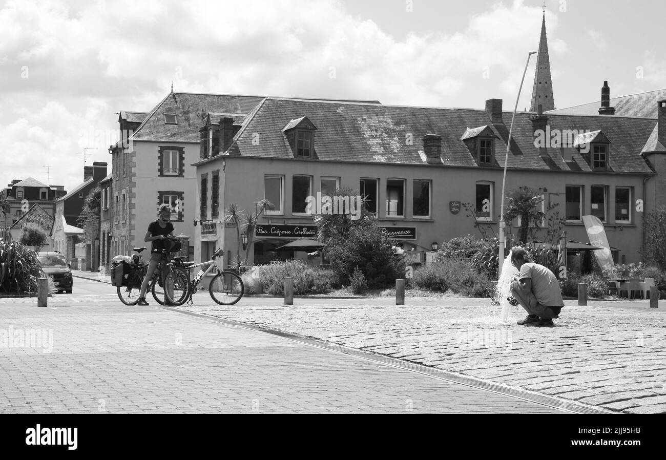 Radfahrer halten an den Wasserbrunnen im Zentrum von Caretan, Normandie, Frankreich, Europa Stockfoto