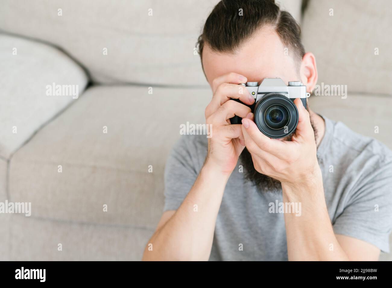 Fotoausrüstung Mann hält Kamera aussehendes Objektiv Stockfoto