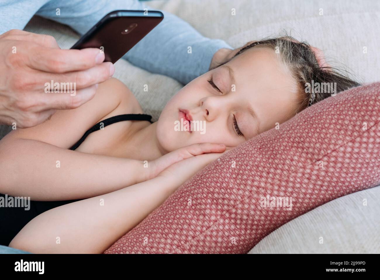 Elternmomente schlafen Tochter Handy Foto Stockfoto