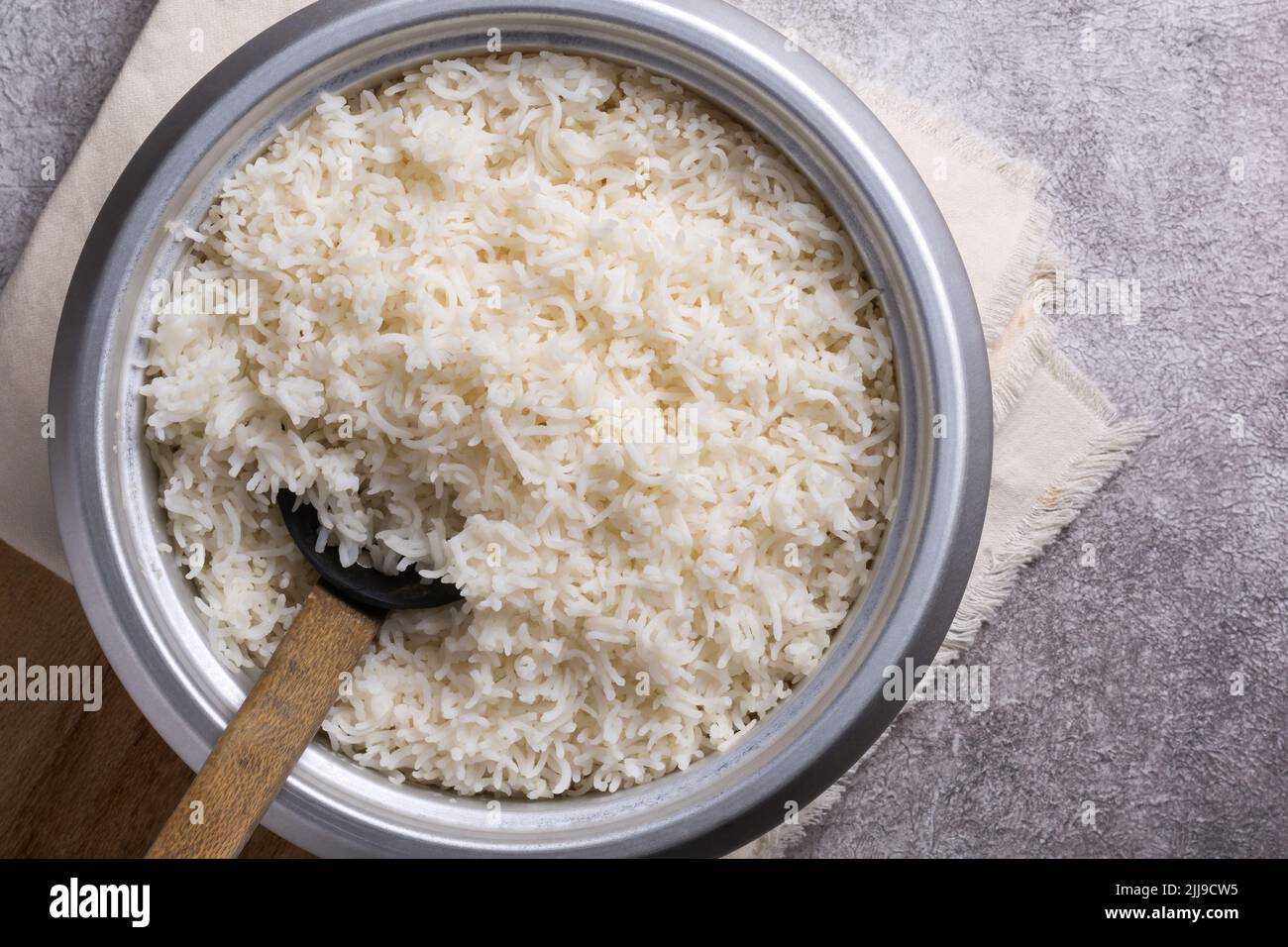 Topf mit gekochtem weißen Basmati-Reis mit einem Holzlöffel, einfach gekocht langkörnigen aromatischen Reis auf einer Tischplatte, von oben mit Platz für Text genommen Stockfoto