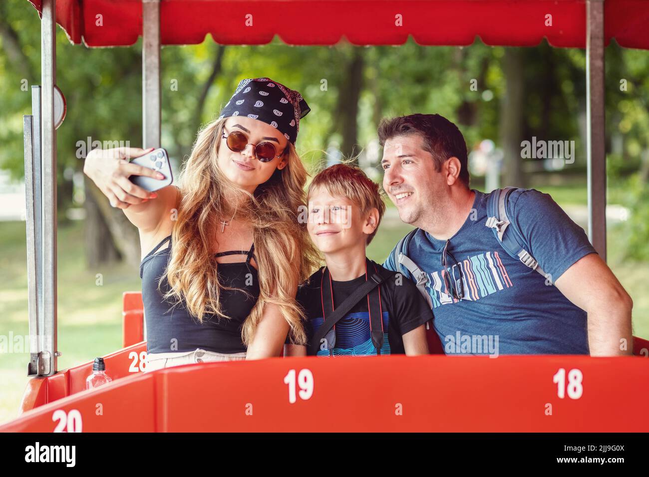 Coole und hippe moderne Familie, die ein Selfie in einem Open-Air-Bus während der Tour Ride Abenteuer Stockfoto