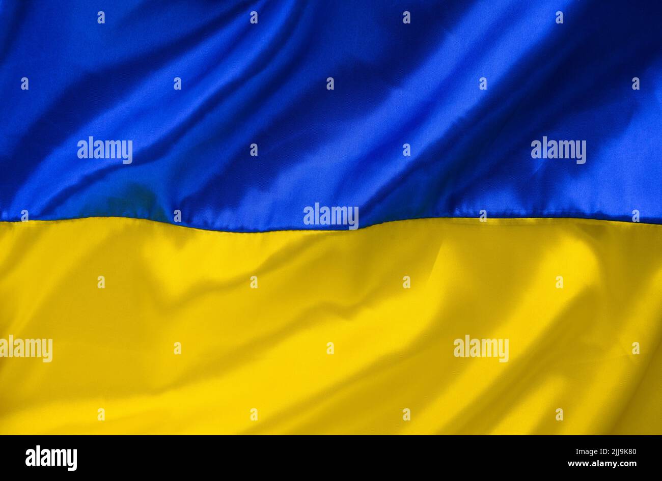 Fabric Wave Flagge der Ukraine, UA. Blaue und gelbe helle Farben. Nahaufnahme gekrümmter Texturhintergrund Stockfoto