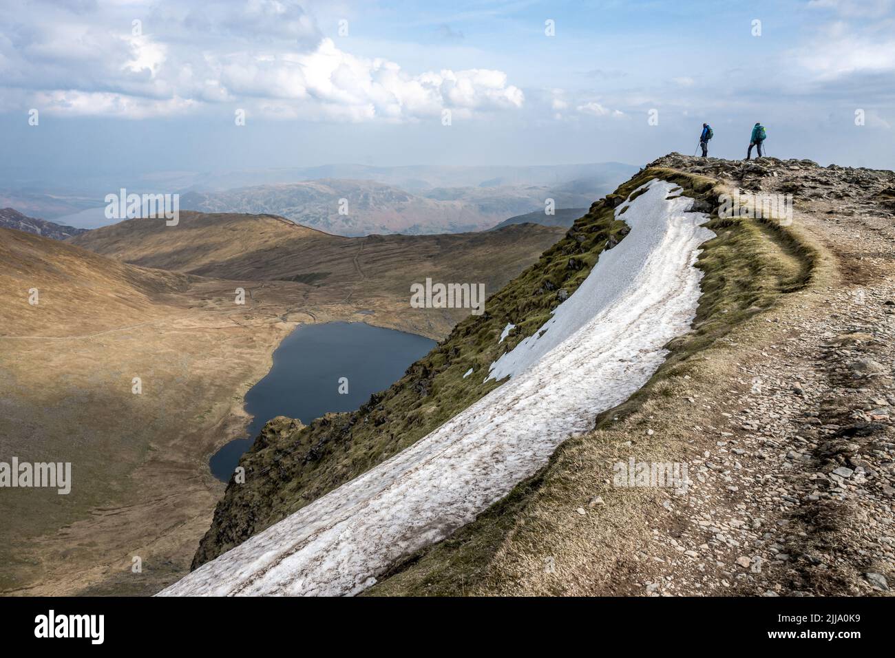 Zwei Wanderer bewundern die Aussicht vom Gipfel des Helvellyn Stockfoto