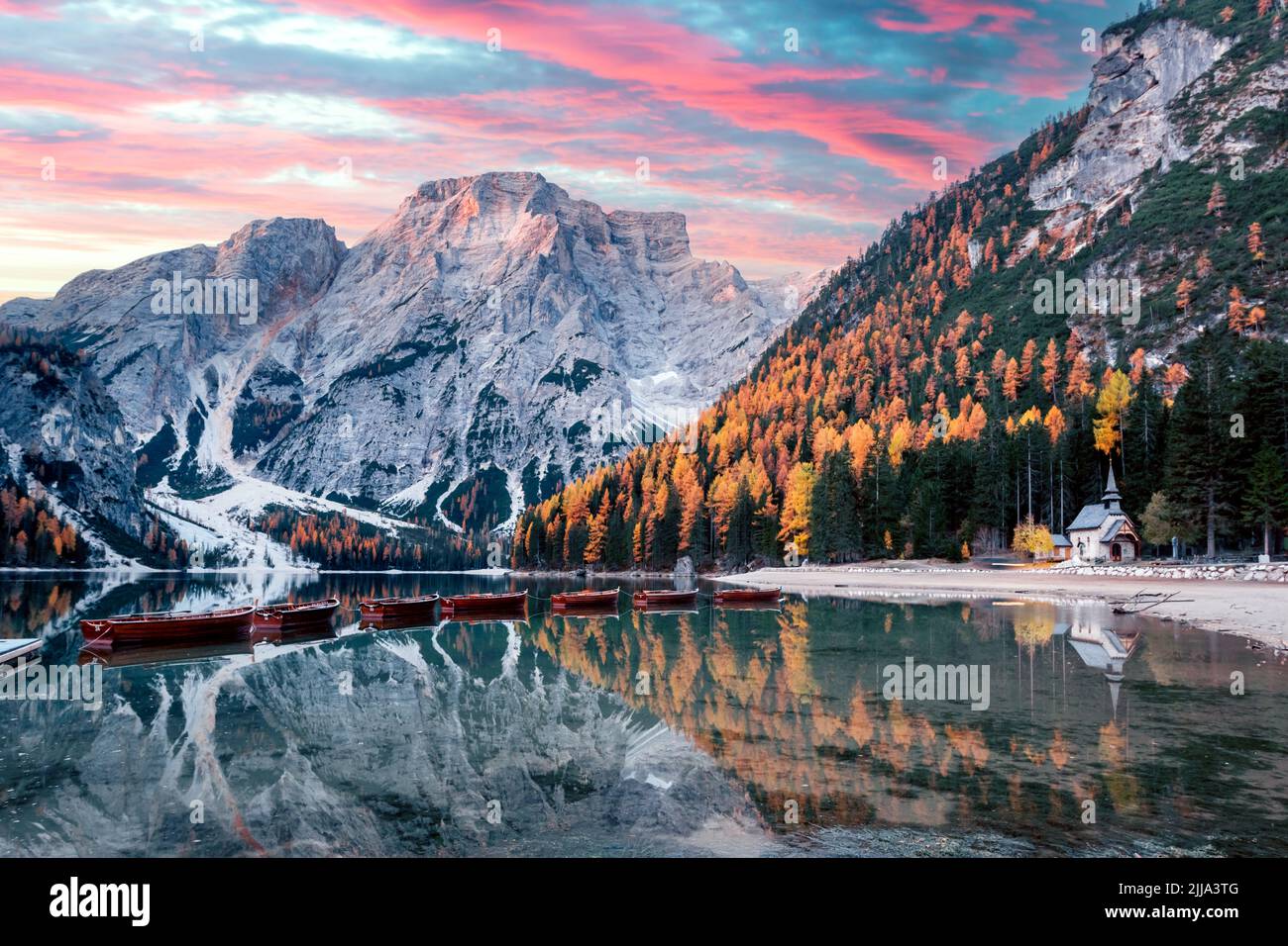 Malerische Landschaft mit dem berühmten Pragser See in den herbstlichen Dolomitenbergen. Holzboote und Pier im klaren Wasser des Pragser Sees, Dolomiten-Alpen, Italien. Seekofel Berggipfel im Hintergrund Stockfoto