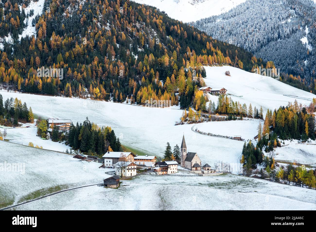 Das berühmte Bergdorf Santa Magdalena mit der Kirche Santa Maddalena in den herbstlichen Dolomiten. Verschneite Berggruppe der Geisler im Hintergrund. Val di Funes, Südtirol, Italien Stockfoto