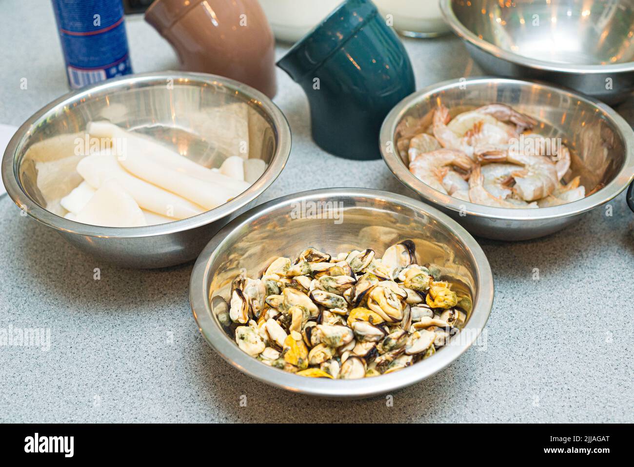 Meeresfrüchte in Metallschüsseln. Rohe Lebensmittel. Muscheln, Garnelen und Tintenfische. Stockfoto