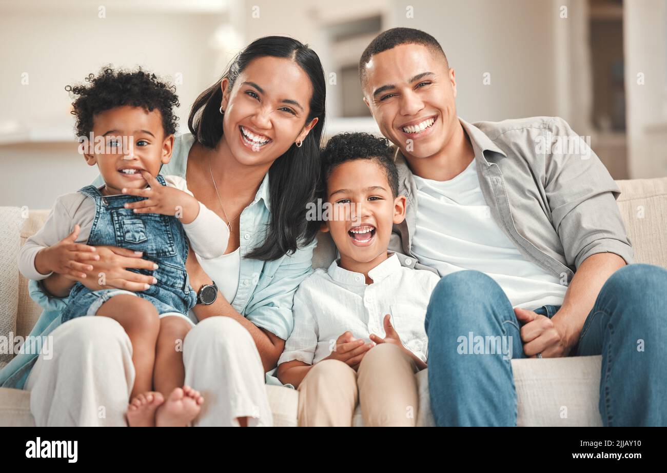 Nur ich und meine Jungs. Eine junge Familie verbindet sich glücklich auf dem Sofa zu Hause. Stockfoto