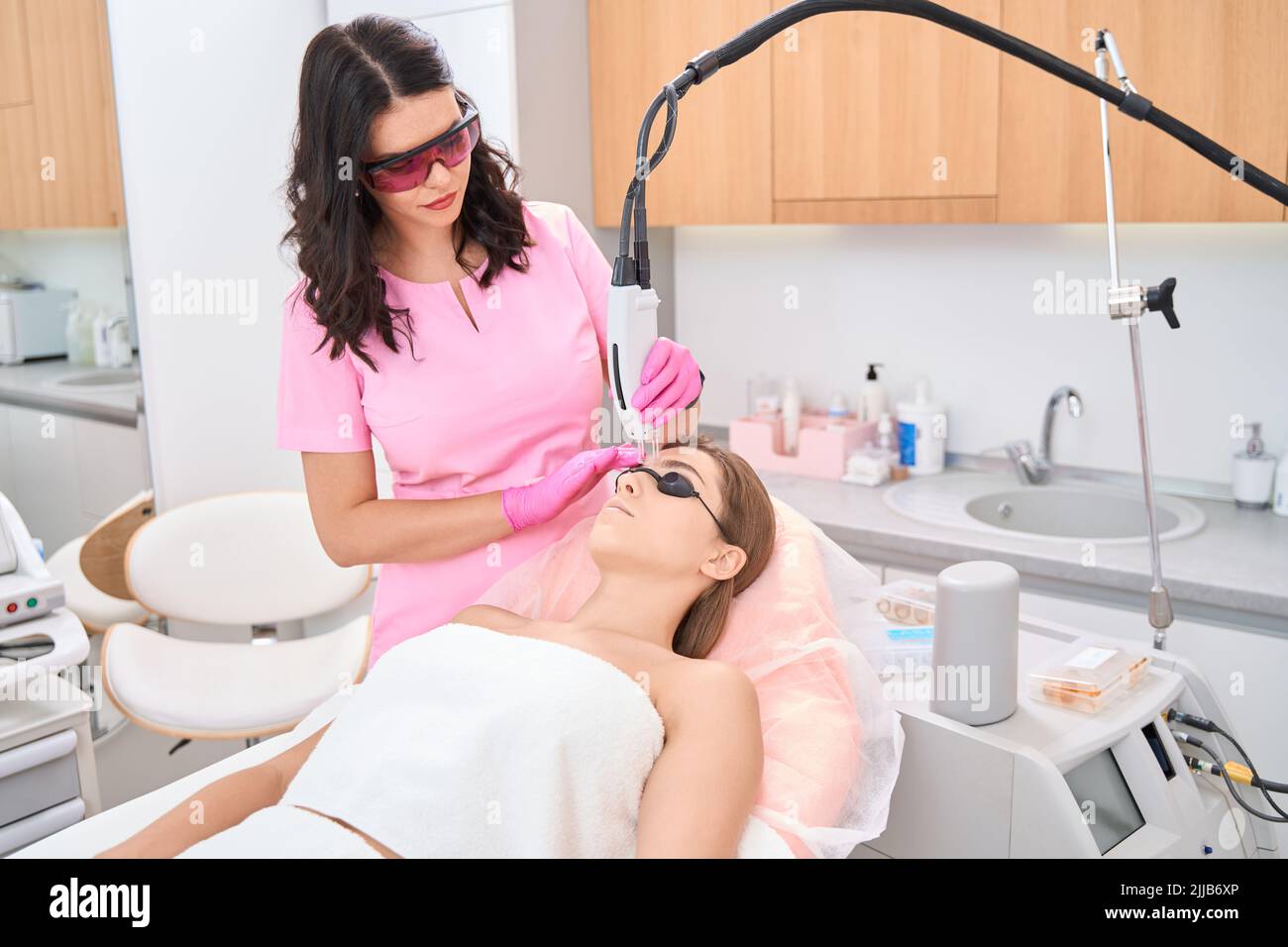 Arzt in medizinischen Uniform und steril arbeiten mit Laser-Hardware Stockfoto