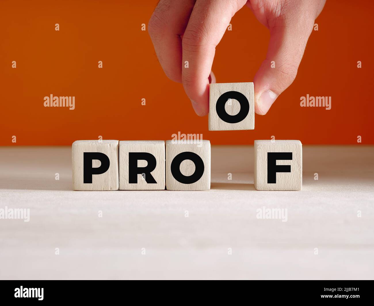 Hand legt den Holzwürfel mit dem Wort Proof. Um einen Beweis zu finden, Beweise zu finden, ein Konzept zu verifizieren oder zu beweisen. Stockfoto