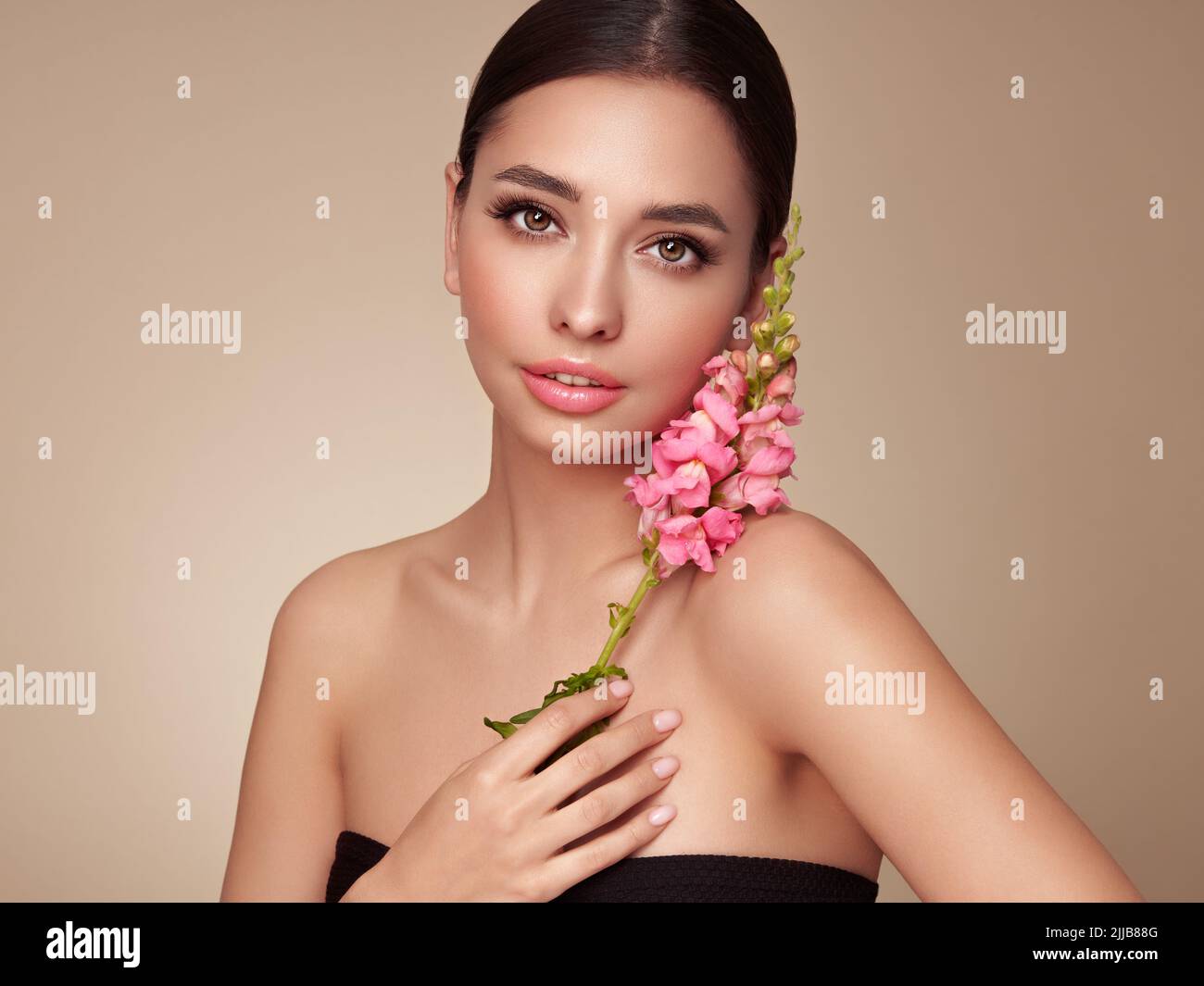 Portrait schöne junge Frau mit sauberer frischer Haut. Model mit gesunder Haut, Nahaufnahme Porträt. Kosmetik, Beauty und Spa. Mädchen mit einer rosa Blüte Stockfoto