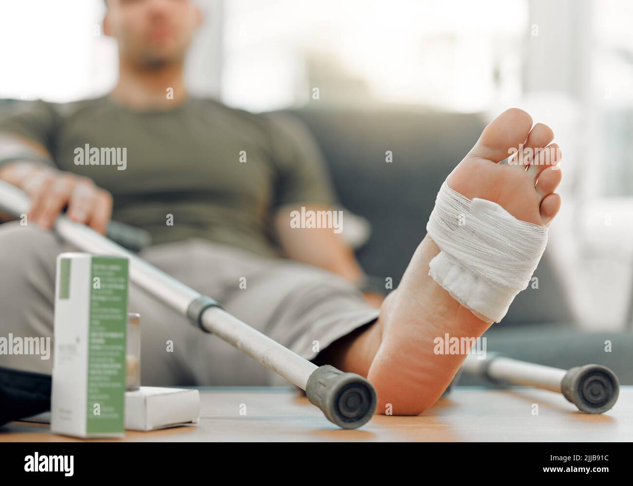 Schreiben Sie Ihre Verletzungen in Staub, Ihre Vorteile in Marmor. Ein unkenntlich Mann entspannt seinen Fuß auf einem Tisch zu Hause. Stockfoto