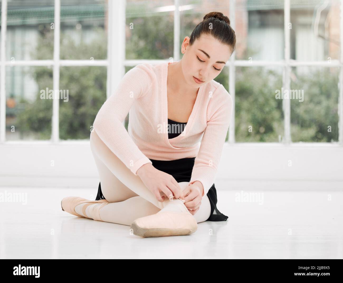 Ich werde heute nicht fallen. Eine schöne junge Ballerina, die sich für das Training in einem Tanzstudio vorbereitet. Stockfoto