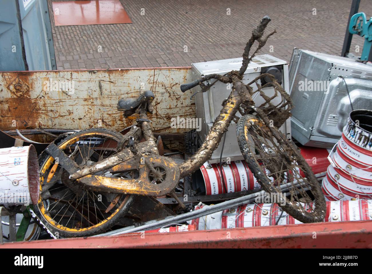 Altes Fahrrad wurde aus dem Hafen gezogen und in einem Müllcontainer abgelagert. Rotterdam. Stockfoto
