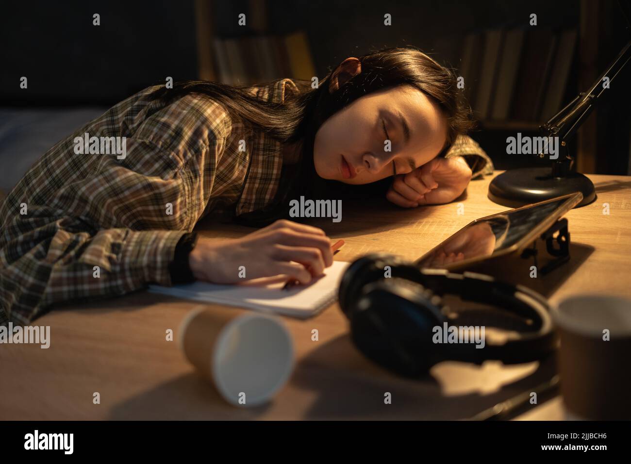 Asiatisch müde Student Frau schlafen auf Tisch bei Nacht zu Hause. Arbeiten von Hausüberlastung in der Nacht, Überstunden, Bildung und Müdigkeit Stockfoto