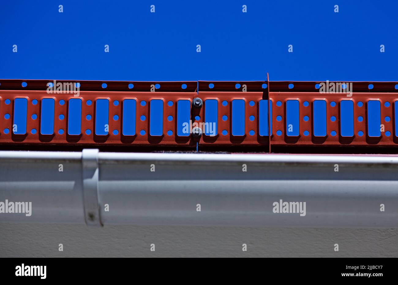 Roter Blechschutz, der sich am Rand einiger Dächer befindet Stockfoto