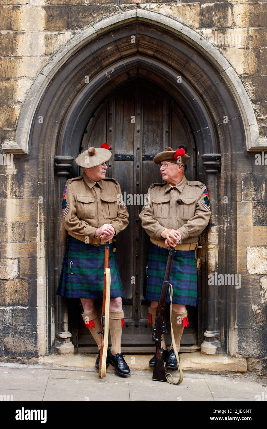 Das Lincoln Festival der 40er Jahre fand im Up Hill Bailgate-Viertel der Stadt in der Nähe des Schlosses und der Kathedrale statt. Zwei Männer, die in historischen Kostümen gekleidet sind, posieren in einer Kirchentür in Bailgate. Stockfoto