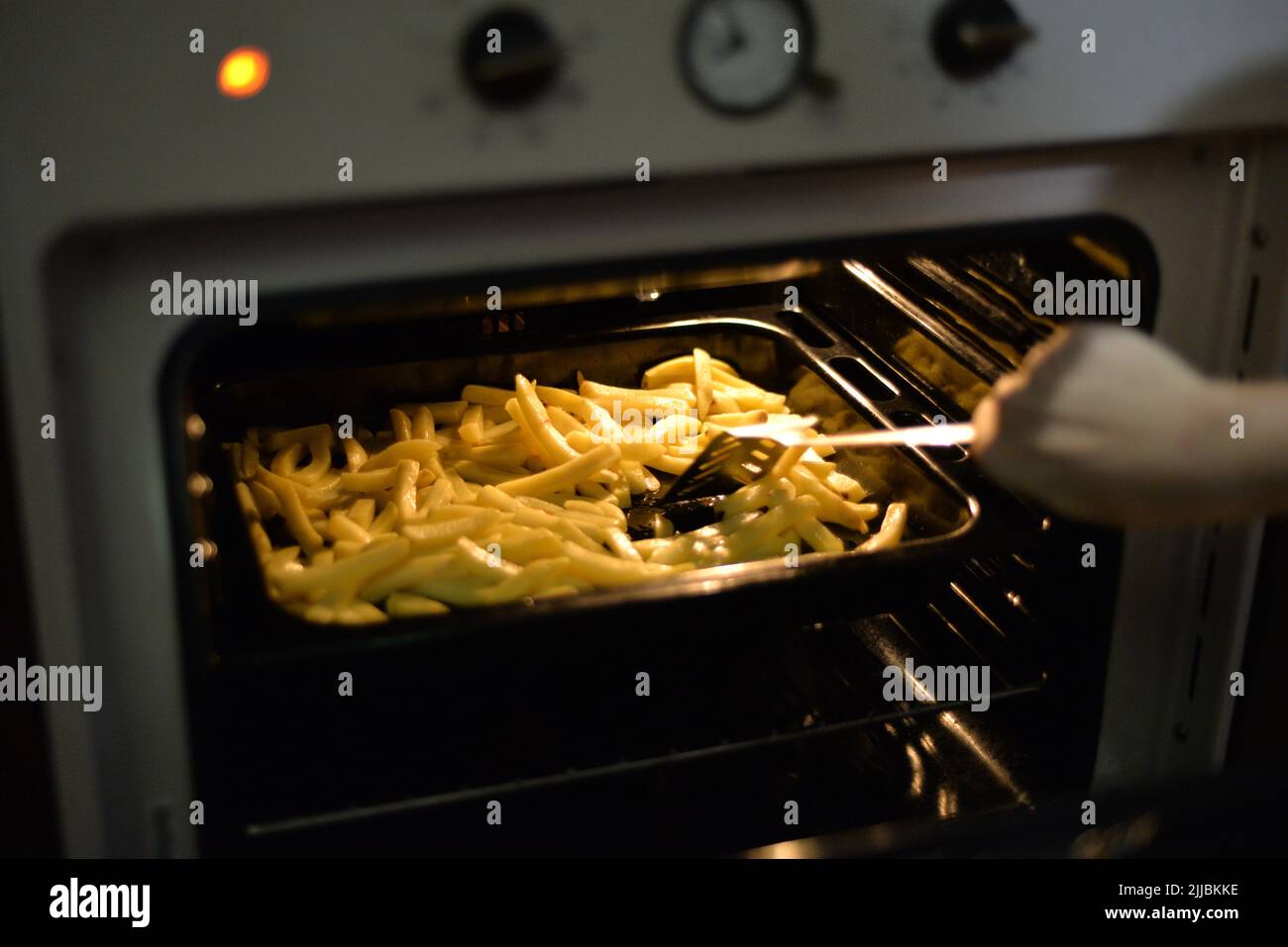 Person, die Kartoffeln im Ofen kocht Stockfoto