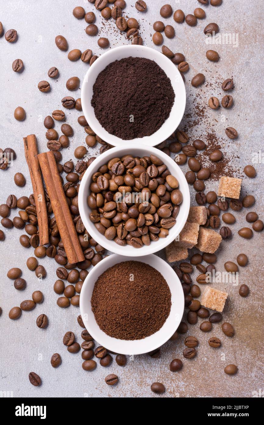 Draufsicht auf geröstete Bohnen und gemahlenen Kaffee mit Zimt und ...
