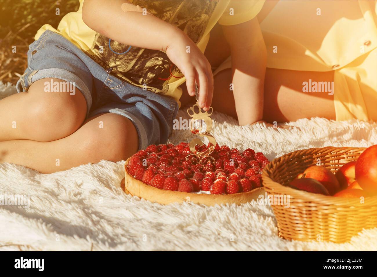 Junge, der Himbeerkuchen mit der Nummer drei isst Stockfoto