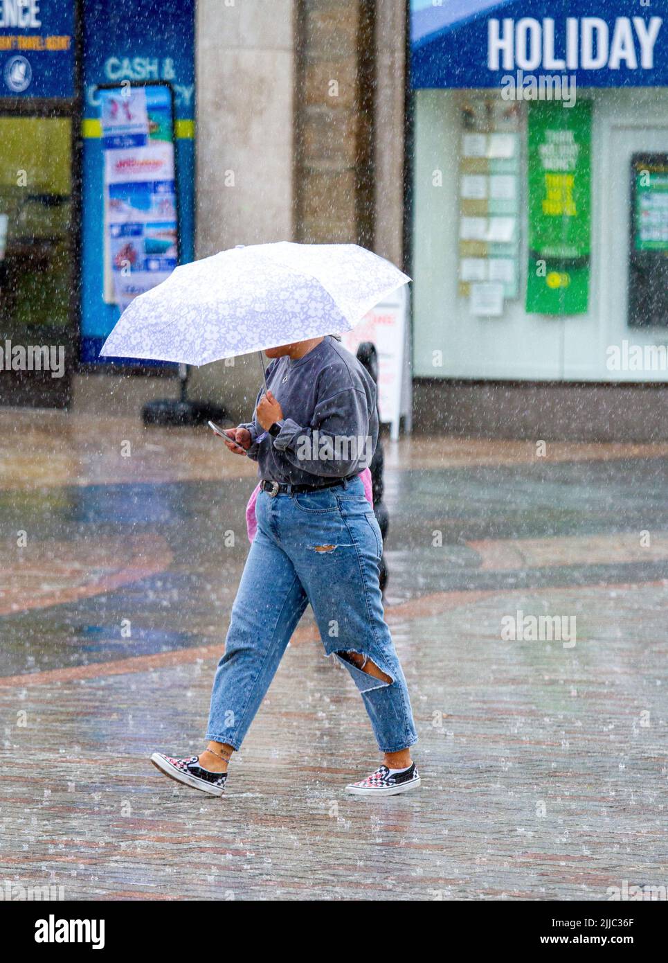 Dundee, Tayside, Schottland, Großbritannien. 25.. Juli 2022. Wetter in Großbritannien: Die Kombination aus unerwarteten, starken Regenschauern und Luftfeuchtigkeit führte in einigen Gebieten Nordostschottlands zu Temperaturen über 18 Grad Celsius. Montagmorgen werden die Käufer von plötzlichen schweren Regengüssen im Stadtzentrum von Dundee überrascht. Kredit: Dundee Photographics/Alamy Live Nachrichten Stockfoto