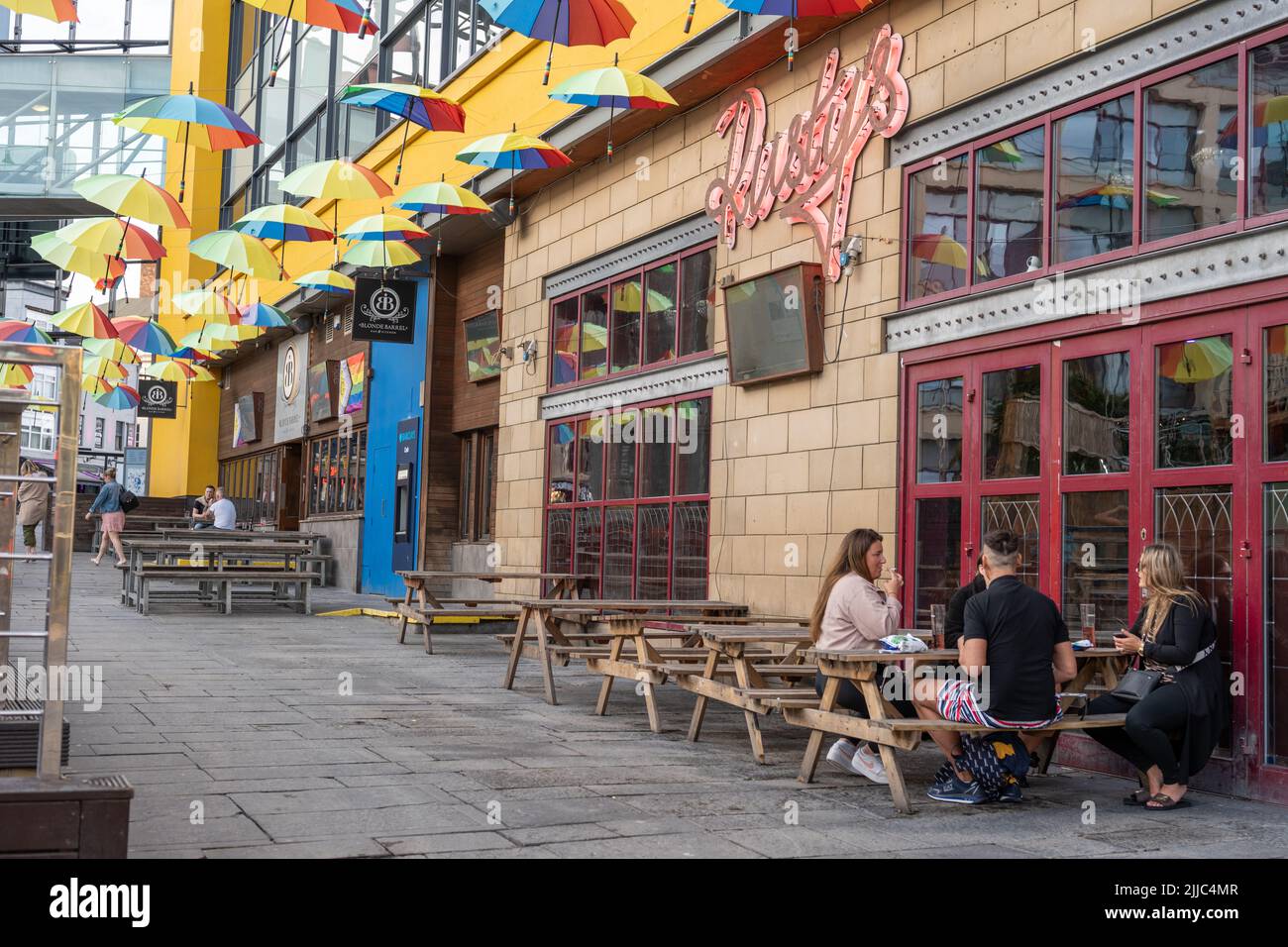 Farbenfrohe Regenschirme schmücken die Bars am Times Square in der Stadt Newcastle upon Tyne zur Feier des britischen Pride. Stockfoto