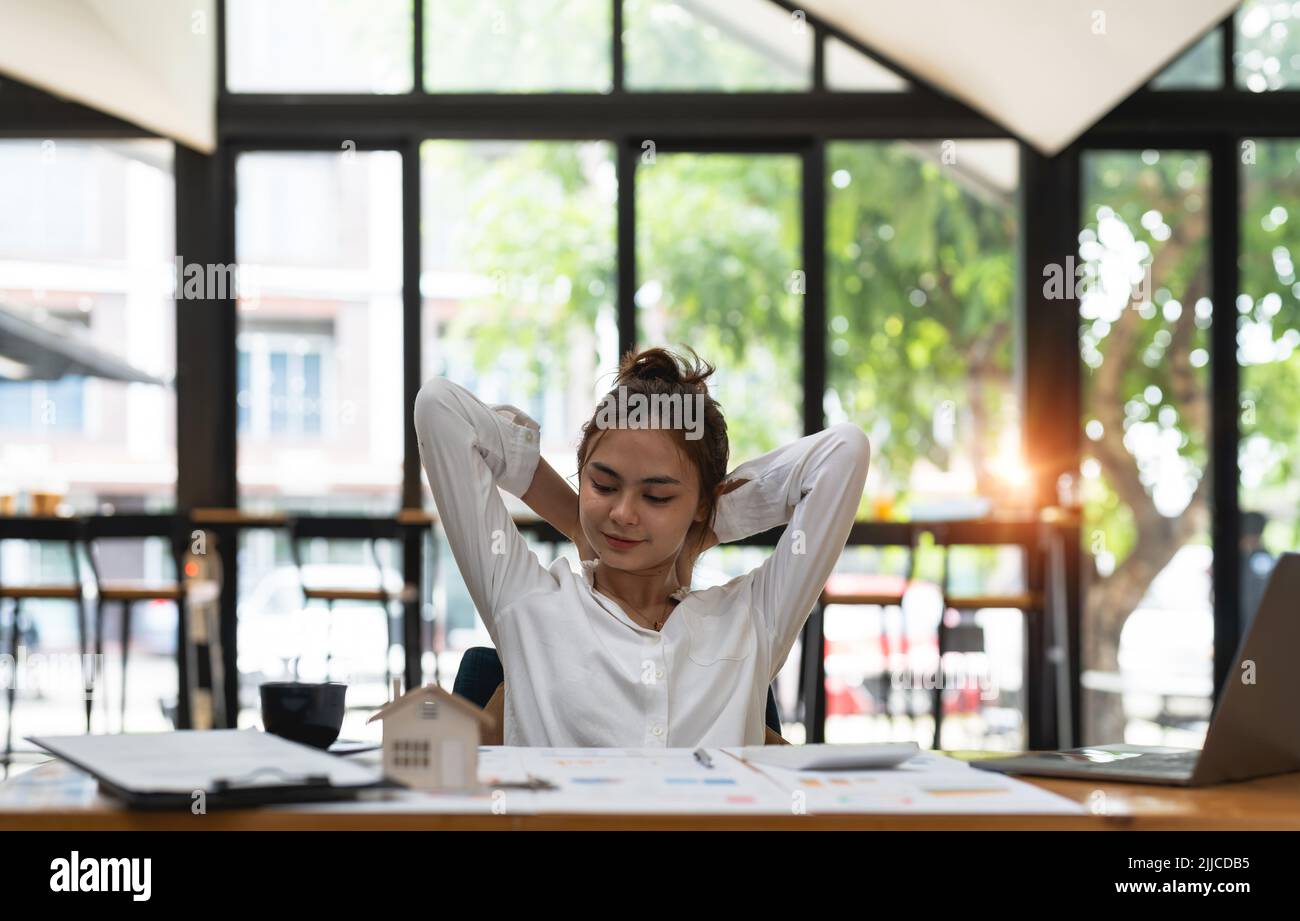 Lächelnder Student mit gemischter Rasse, der sich nach der Arbeit am Laptop entspannt. Stockfoto