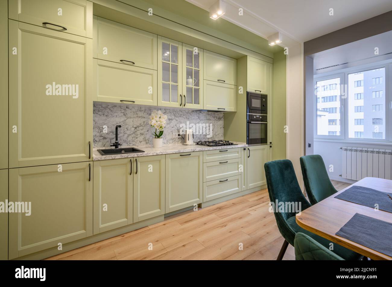 Moderne, hellgrüne, luxuriöse Küche mit Esstisch Stockfoto