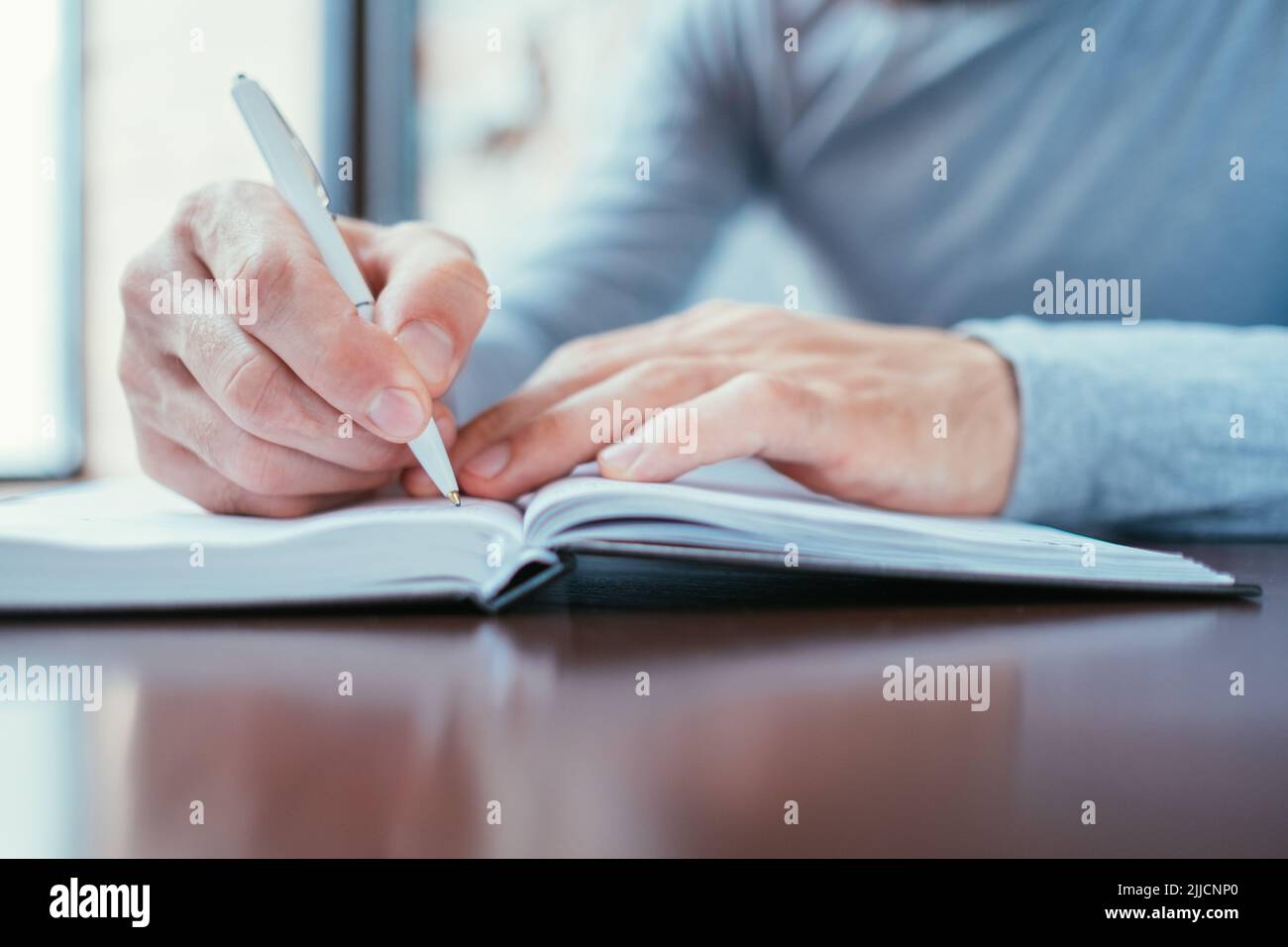 Mann schreiben Notizblock Agenda Zeitplan Kontrolle Angelegenheit Stockfoto