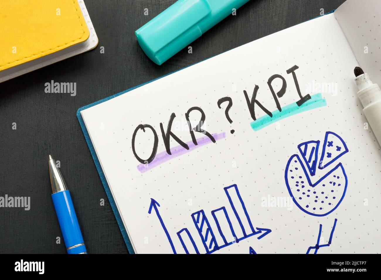 Markierungen im Notizblock OKR oder KPI und Geschäftsdiagrammen. Stockfoto